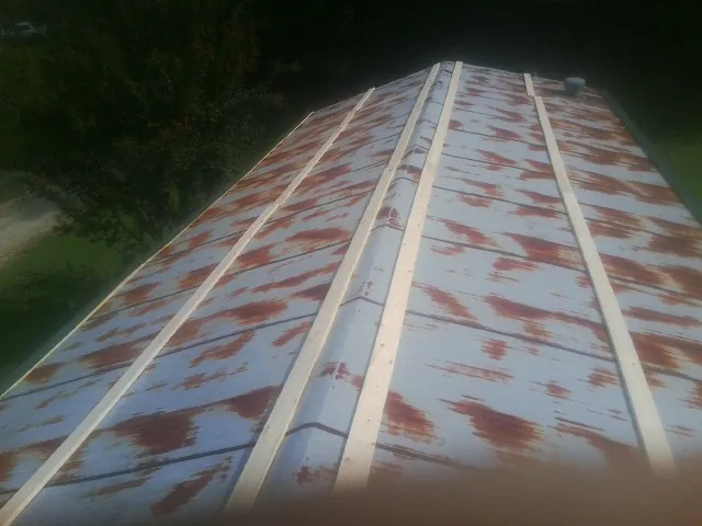 Rusted metal roof panels with new wood purlins before replacement — Storm Damage Roof Repair in El Campo by Roofing Brothers