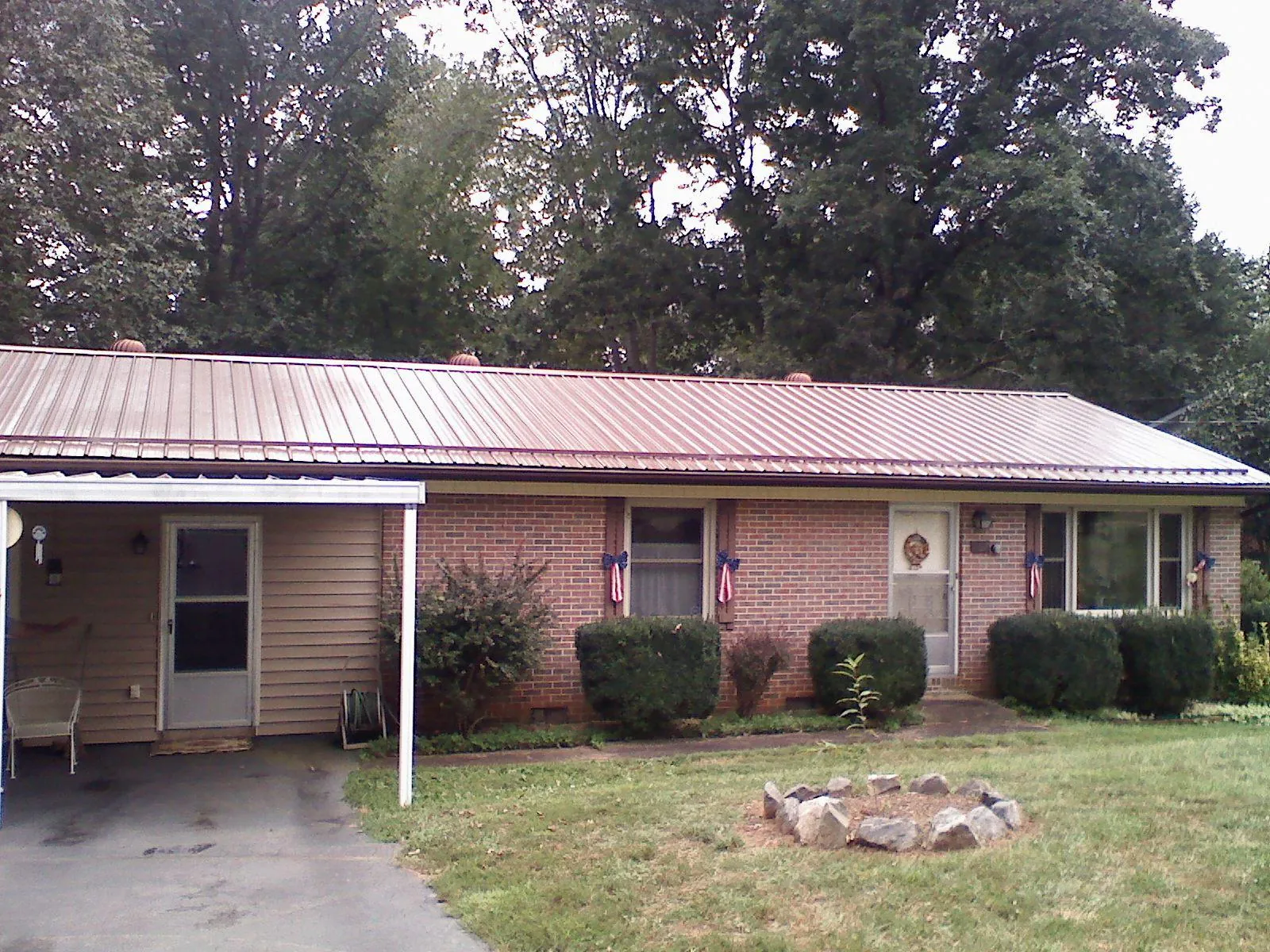 Bronze metal roof and carport on a brick ranch home — Roof Repair work by our crew in El Campo