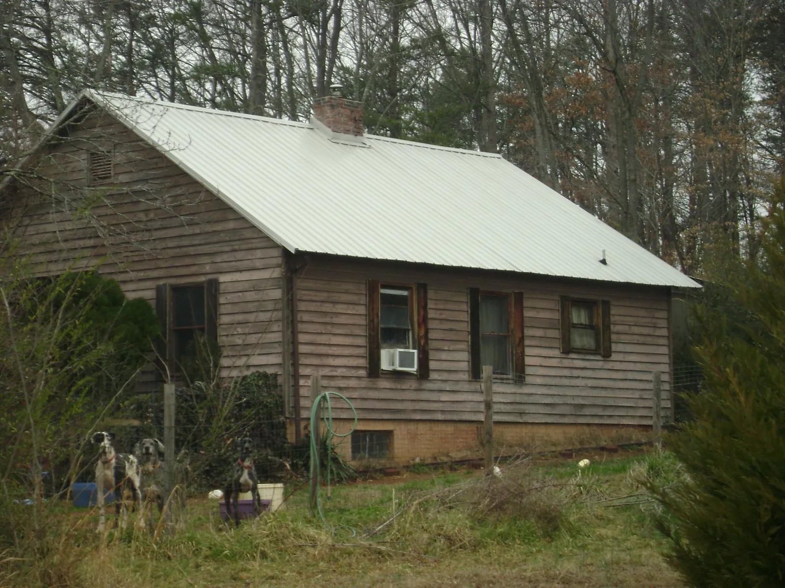 White metal roof on an old wood sided farmhouse, from a Metal Roof Installation job in El Campo